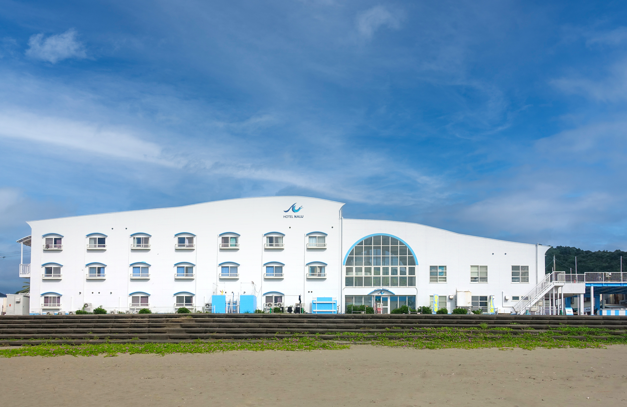 Hotel NALU — 東洋町生見 · 生見サーフビーチの砂浜から見た白い外観
