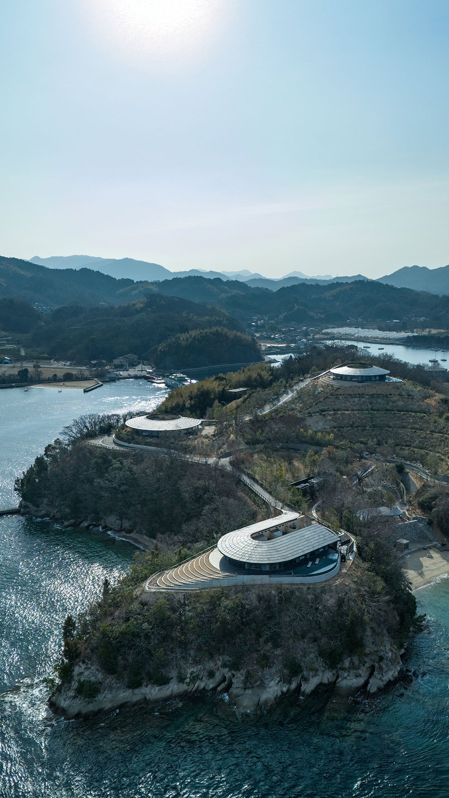 NOT A HOTEL SETOUCHI — 佐木島の半島を上空から望む · 斜面に沿って配された3棟のヴィラ