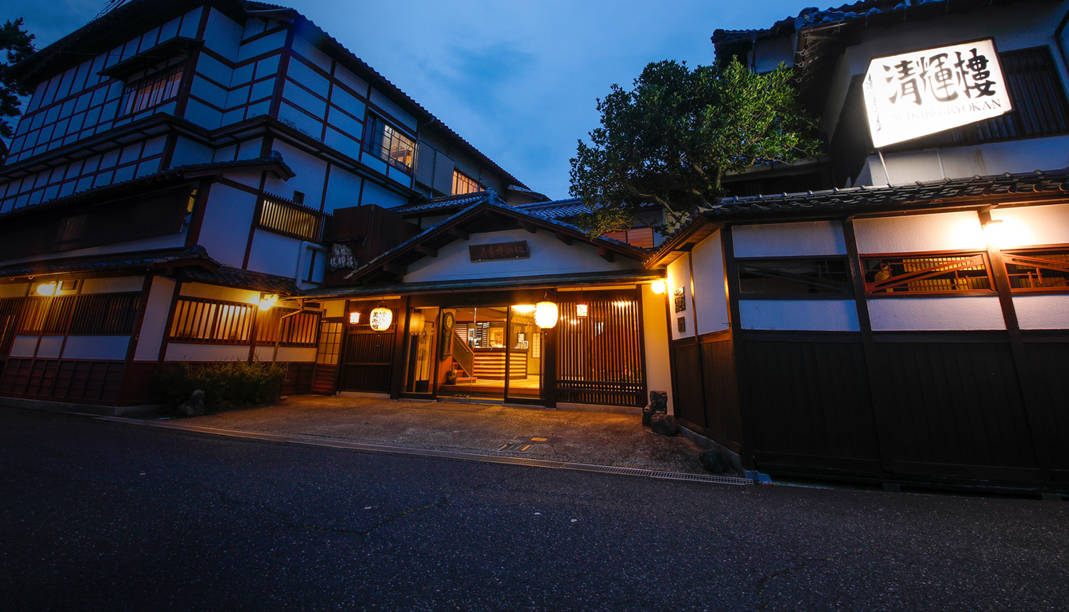 文人墨客の宿 清輝楼 — 宮津・魚屋 · 数寄屋造りの木造建築が青の夕暮れに灯る登録有形文化財の港町旅館