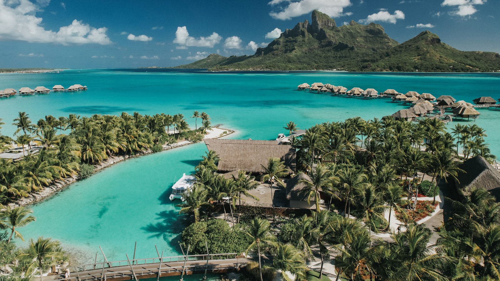 Four Seasons Resort Bora Bora — 仏領ポリネシア · ターコイズの潟湖に並ぶ水上バンガローとオテマヌ山の空撮