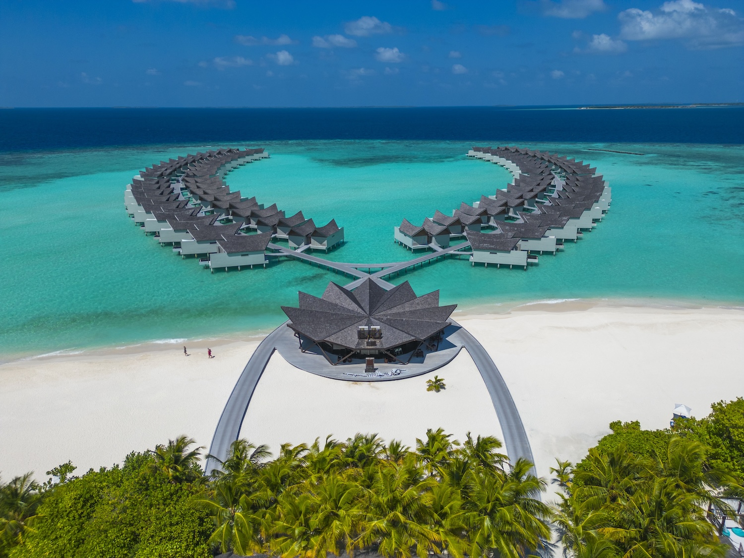 モンドリアン・モルディブ — クレディヴァル島のリゾート全景 · 白い建築とプール、南国植物が礁湖の縁に連なる