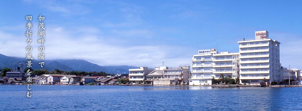 湖畔の宿 吉田家 — 佐渡・両津夷 · 加茂湖の対岸から望む館影、背後に大佐渡山地