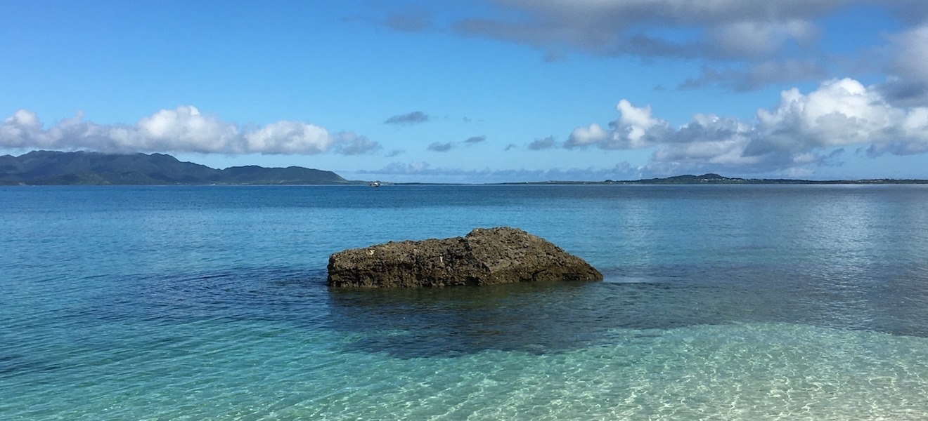 しま宿南来 — 黒島 · リーフの内側に広がる浅瀬と、水平線に横たわる西表島の島影