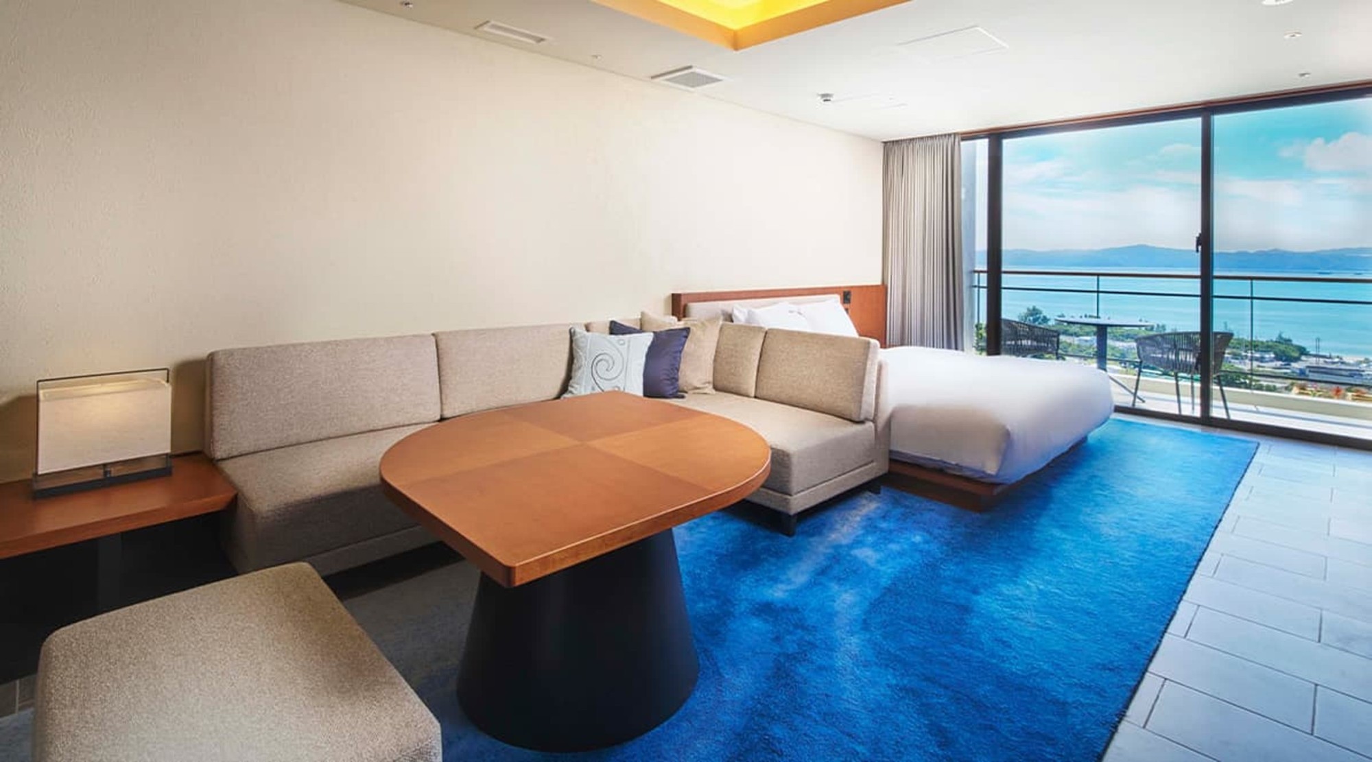 BATON SUITE 沖縄古宇利島の客室 — 67.4平米のスイート、窓の外に古宇利島の海が広がるリビング