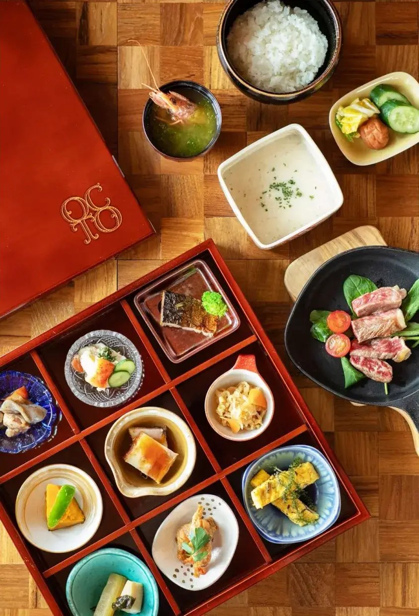 BATON SUITE 沖縄古宇利島 OCTOの和朝食 — 松花堂に9品の豆皿料理と沖縄県産牛ステーキが並ぶ