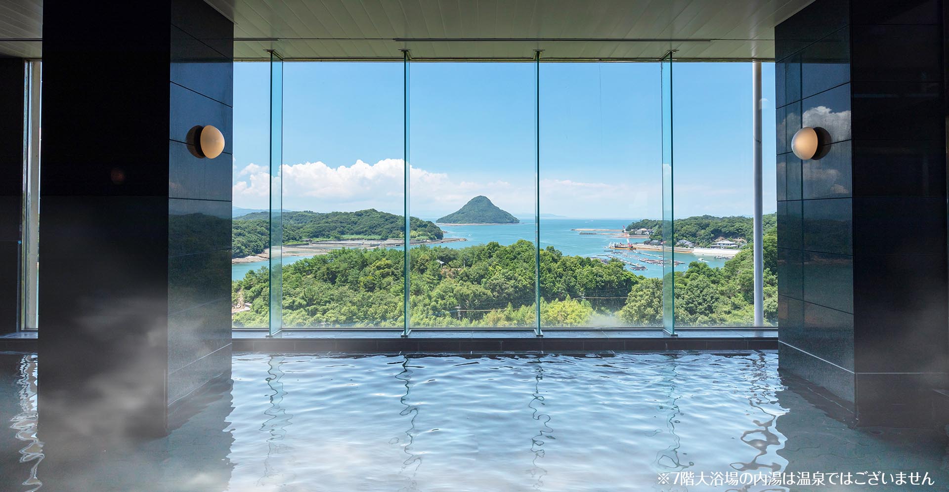 大江戸温泉物語 天草ホテル亀屋 — 熊本県上天草市大矢野町 · 7階大浴場のガラス越しに天草の海と島を望む(内湯は温泉ではない)