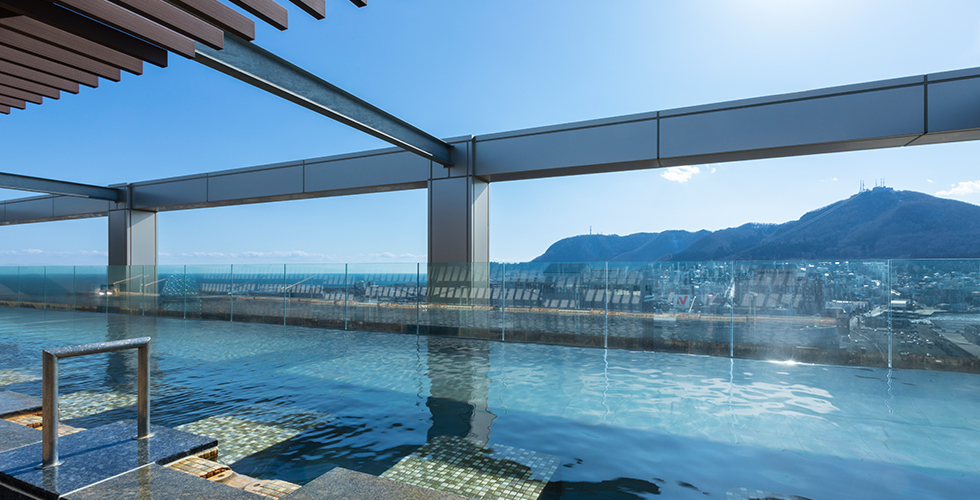 HOTEL&SPA センチュリーマリーナ函館 — 函館市大手町 · 天空露天風呂、縁の向こうに函館山と市街