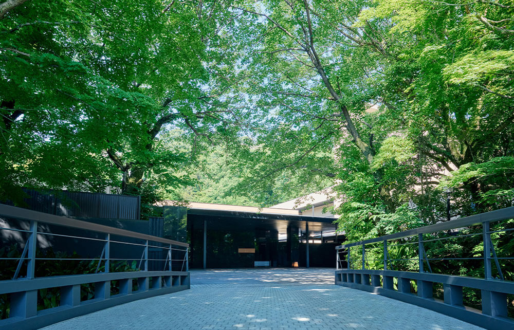 ふふ熱海 — 熱海市水口町 · 木々に包まれた橋の先にある本館エントランス