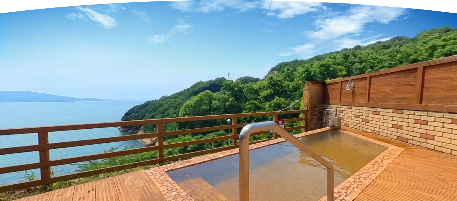 ホテルグリーンプラザ小豆島 — 土庄町伊喜末 · 木のデッキに据えた露天風呂と、岬の緑の先に開ける瀬戸内海
