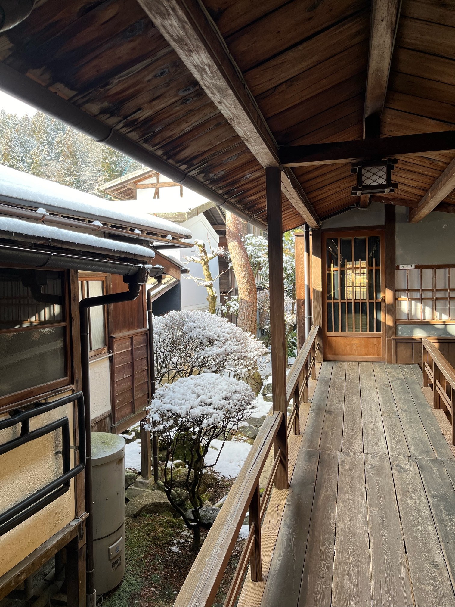 松代屋旅館 — 長野県南木曽町・妻籠宿 · 雪の中庭に面した板張りの回廊と、木の引き戸が残る旅籠の内部