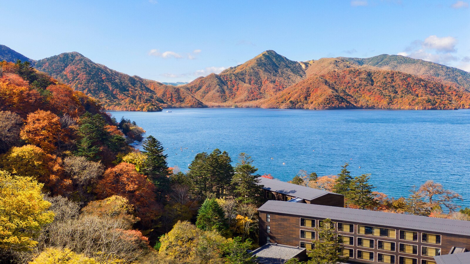 男体山が湖面に影を落とし、紅葉が岸辺まで降りてくる——各国の大使が夏を過ごした中禅寺湖の畔に、国際ブランドが置いた94室を一軒で読む