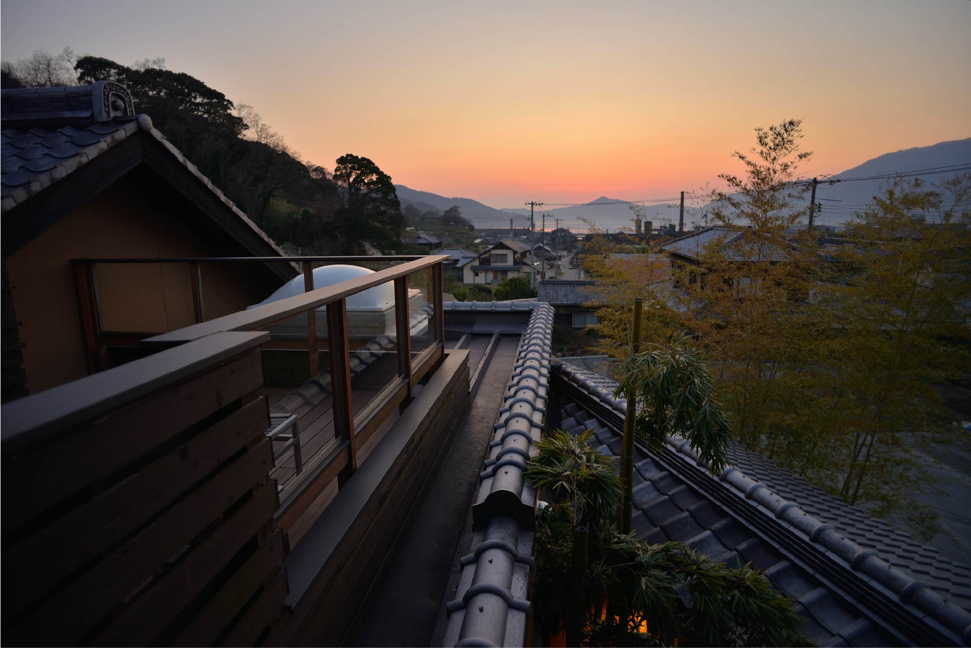 島宿 真里 — 小豆島町・苗羽 · 瓦屋根の向こうに夕暮れの海と山並みを望む醤の郷の宿
