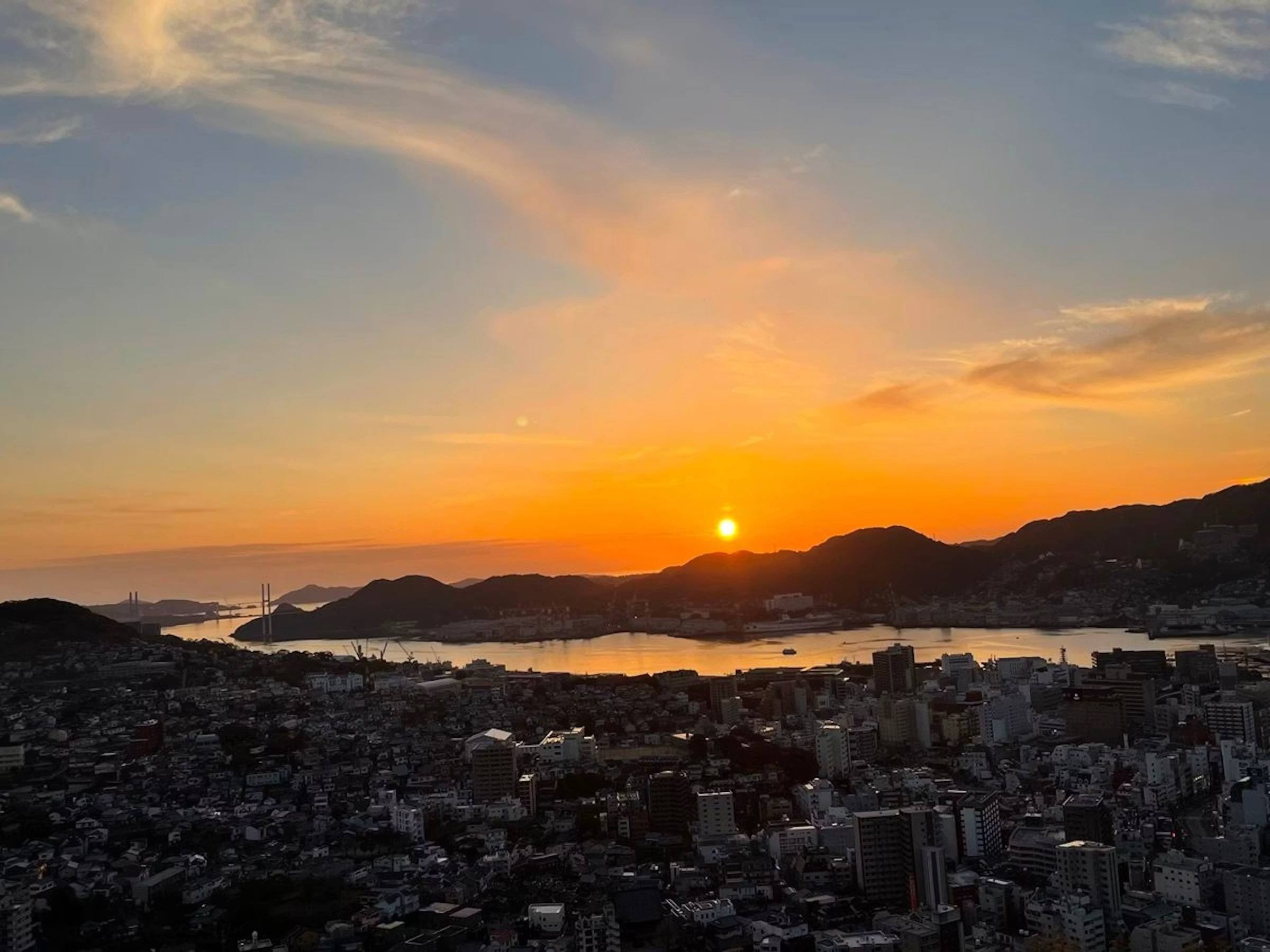 矢太樓・矢太樓南館 — 長崎市風頭町 · 標高170mの風頭山から望む長崎の市街と、港の先に沈む夕陽