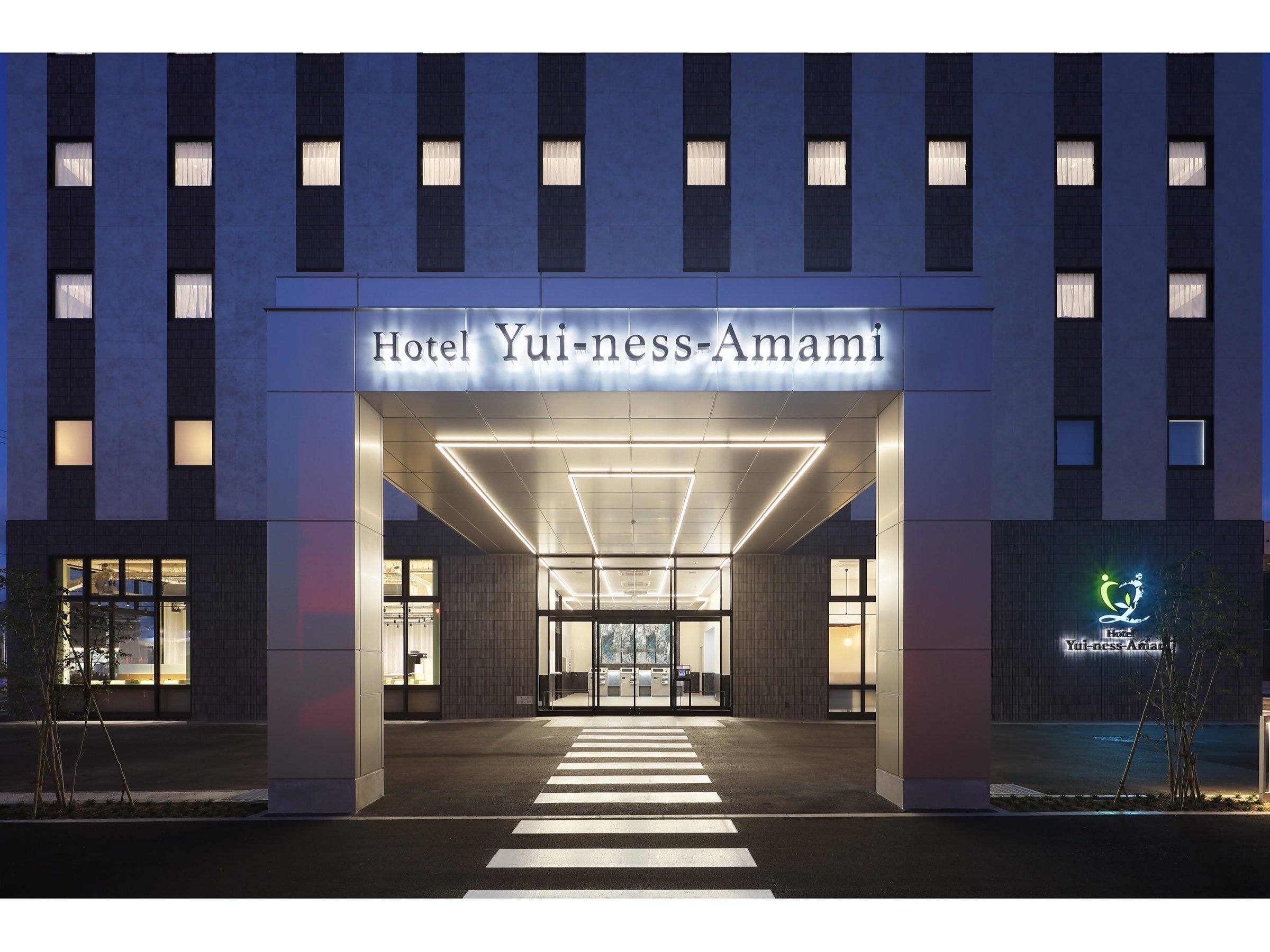 Hotel Yui-ness-Amami マリンタウン — 奄美市名瀬矢之脇町 · 2025年10月開業、全135室のホテルの夜のエントランス